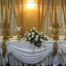 A long table with a bouquet and candlesticks