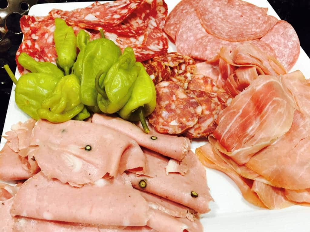A plate of deli meats and bell peppers